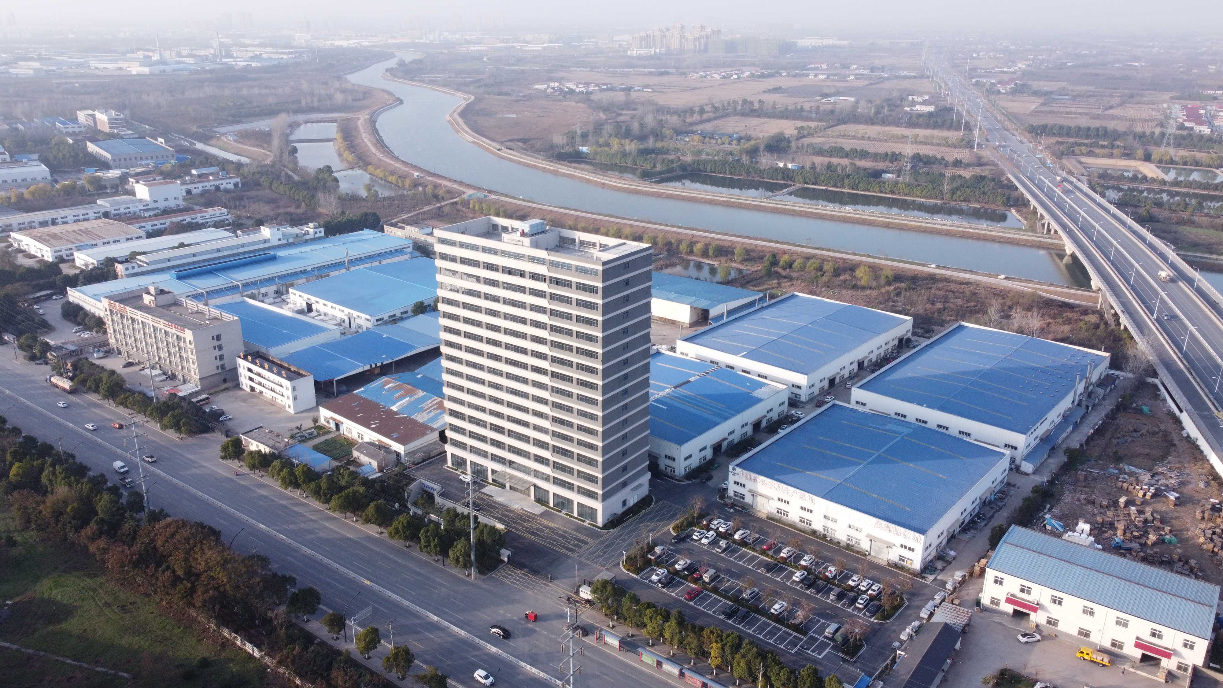 现代化桥梁建设现场，钢筋混凝土桥墩高耸，桥面结构完整，跨越河流两岸